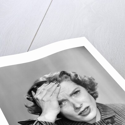1950s Stressed Woman In Striped Dress Hold Forehead With Hand by Anonymous