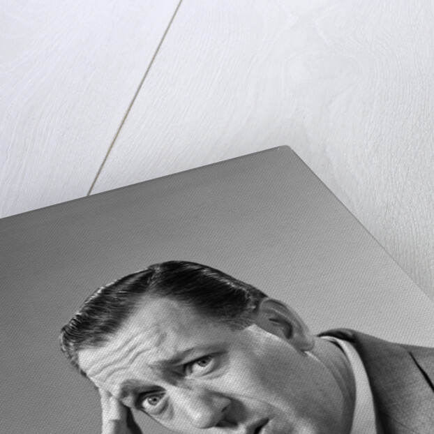 1960s Portrait Man In Suit and Tie With Wrinkled Brow Wincing and Holding Forehead by Anonymous