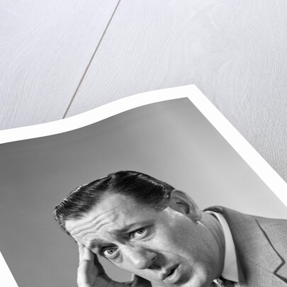 1960s Portrait Man In Suit and Tie With Wrinkled Brow Wincing and Holding Forehead by Anonymous