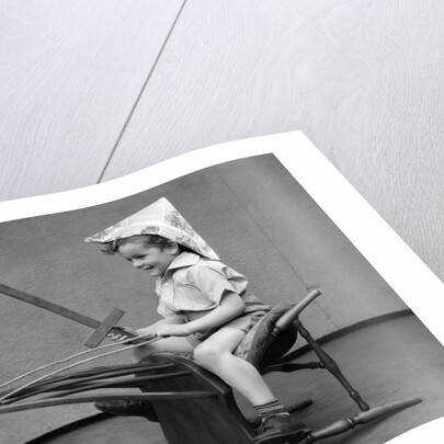 1930s Boy Playing Wooden Sword Paper Hat Riding Chair Like A Horse by Anonymous