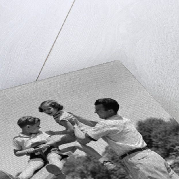1950s Father Lifting Son And Daughter Onto A Playground Seesaw Outdoor by Anonymous