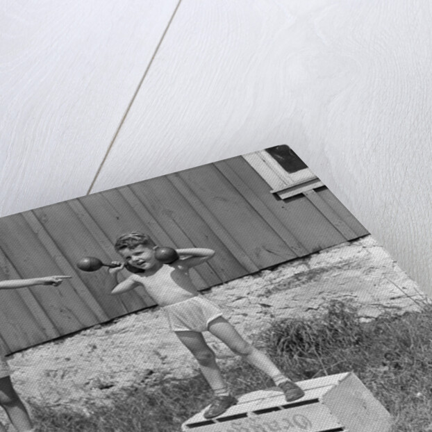 1930s 1940s Boys Playing Carnival Strongman One Lifting Dumbbells Other Announcing Act Through Megaphone by Anonymous