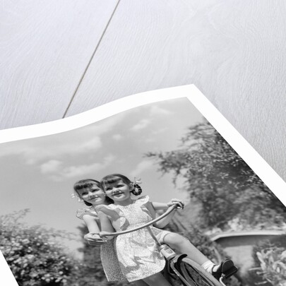 1940s Twin Girls Riding Outside On Tricycle by Anonymous