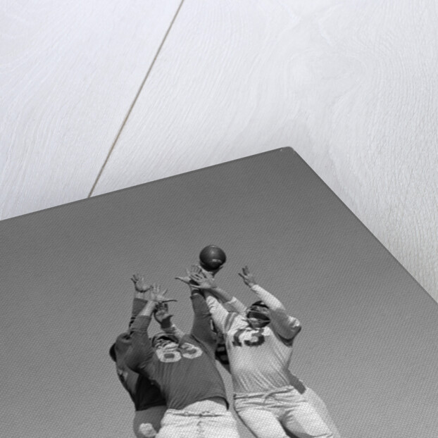 1960s Three Football Players Reaching To Catch Ball by Anonymous