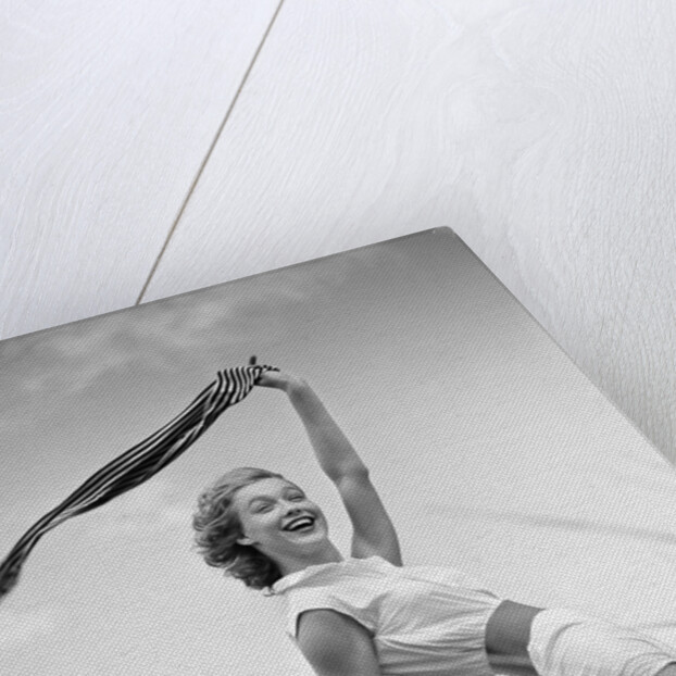 1950s 1960s Young Woman Bending Back Holding Scarf In The Wind Standing On Grassy Beach Dune by Anonymous