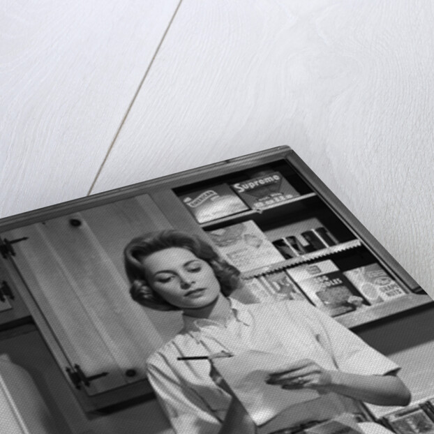 1960s Woman Housewife In Kitchen Checking Grocery Food Shopping List by Anonymous