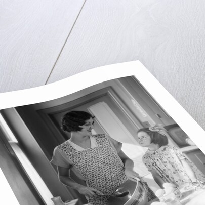 1920s 1930s Mother With Mixing Bowl In Kitchen With Daughter by Anonymous