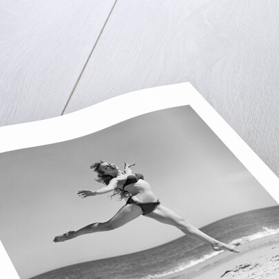 1950s Woman In Bikini Running And Jumping On The Beach Smiling by Anonymous