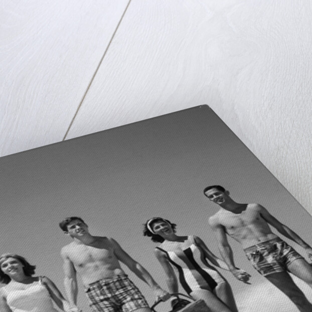 1960s Teenage Couples Wearing Bathing Suits On Beach Carrying Picnic Baskets by Anonymous