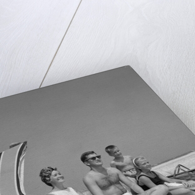 1960s Family Portrait Mother Father Daughter And Two Sons Sitting On Beach Under Umbrella by Anonymous