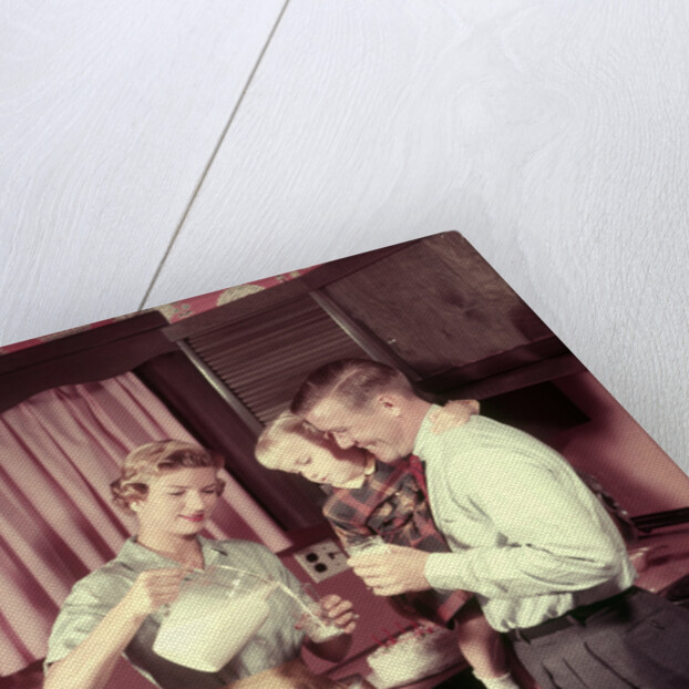 1950s Family In Kitchen Mother Pouring Milk From Pitcher For Dad And Kids by Anonymous