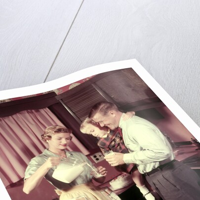 1950s Family In Kitchen Mother Pouring Milk From Pitcher For Dad And Kids by Anonymous