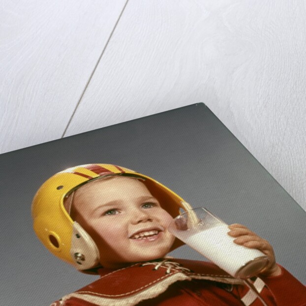 1950s 1960s Boy Drinking Glass Milk Wearing Football Helmet Shoulder Pads by Anonymous