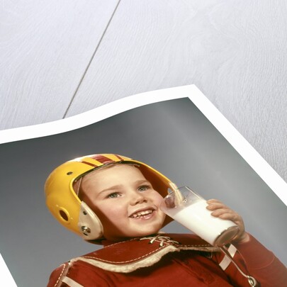 1950s 1960s Boy Drinking Glass Milk Wearing Football Helmet Shoulder Pads by Anonymous