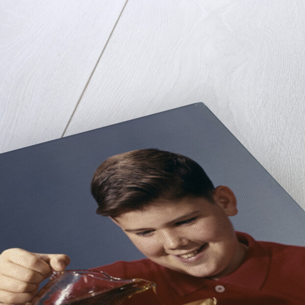 1950s 1960s Boy Pouring Syrup On Breakfast Pancakes by Anonymous