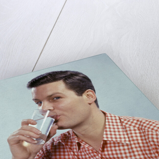 1960s Man Drinking Glass Water Wearing Red Checkered Shirt by Anonymous