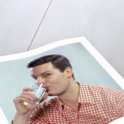 1960s Man Drinking Glass Water Wearing Red Checkered Shirt by Anonymous