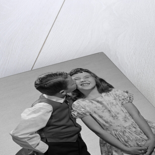 1950s 1960s Boy In Vest and Bow Tie Holding Valentine Candy Kissing Cheek Of Girl Making A Face by Anonymous