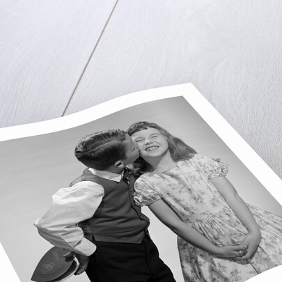 1950s 1960s Boy In Vest and Bow Tie Holding Valentine Candy Kissing Cheek Of Girl Making A Face by Anonymous
