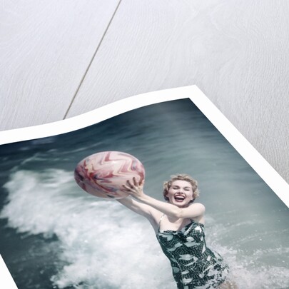 1950s Woman Jumping In Surf Holding Up Beach Ball by Anonymous