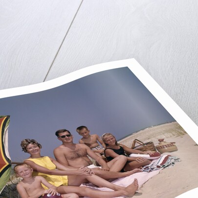 1960s Family On Sunny Beach Under Umbrella With Picnic Basket by Anonymous