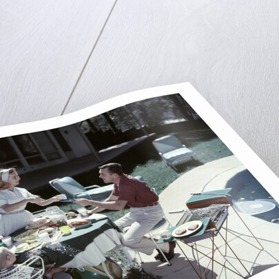 1950s Family In Backyard Having Picnic From Grill Near Swimming Pool by Anonymous
