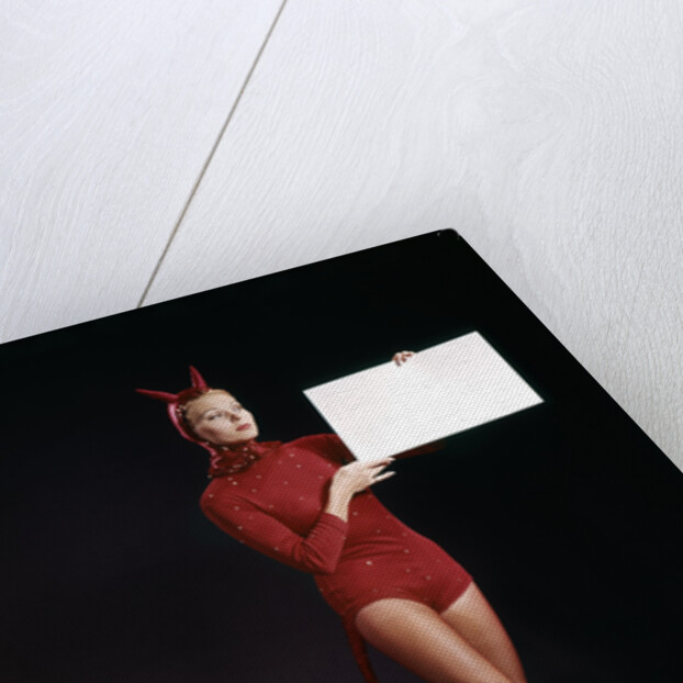 1960s Young Woman In Red Devil Costume Holding Sign Board In Hands by Anonymous
