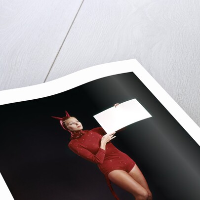 1960s Young Woman In Red Devil Costume Holding Sign Board In Hands by Anonymous