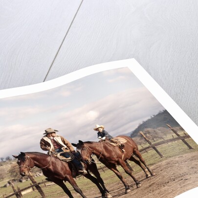 1970s Father And Son Sitting Together On Horses By Corral Wearing Hats by Anonymous