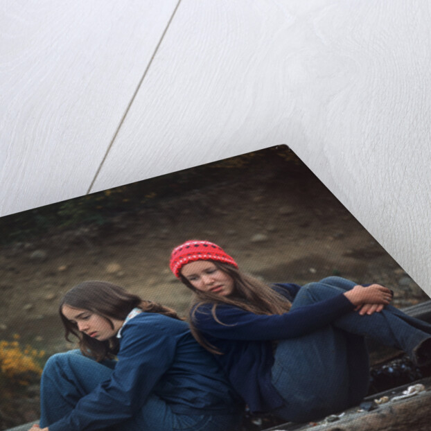 1970s Two Sad Serious Teenage Girls Sitting Back To Back Outside by Anonymous