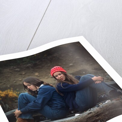 1970s Two Sad Serious Teenage Girls Sitting Back To Back Outside by Anonymous