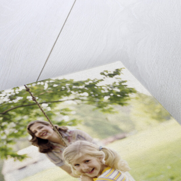1970s Woman Mother With Girl Daughter Swinging Playing On Rope Swing by Anonymous