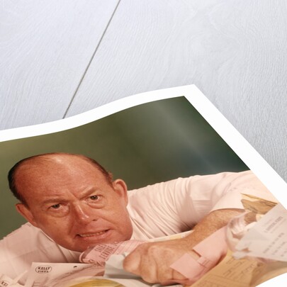 1960s Angry Man Businessman Desk Full Of Bills Paper Work Office Stress Frustration by Anonymous