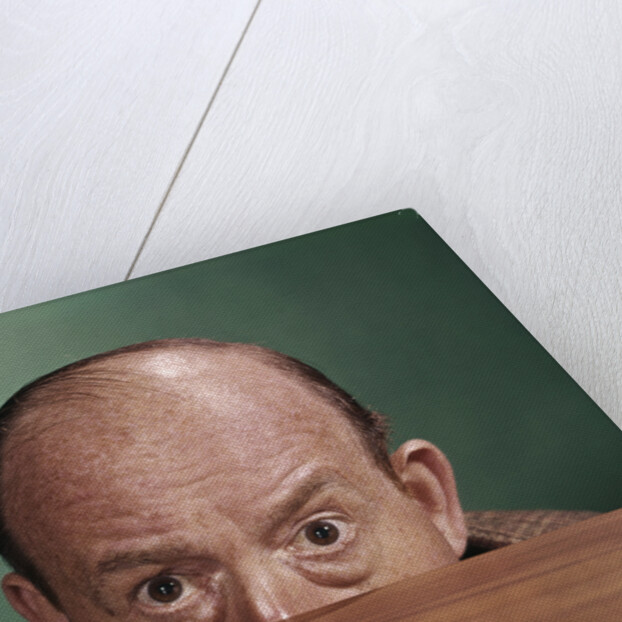 1960s Balding Man Peeking Over Desktop With Only Top Half Of Head Showing by Anonymous