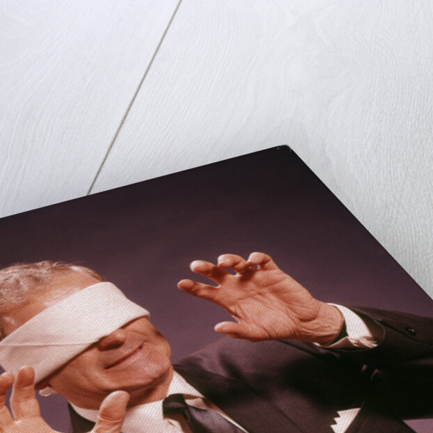 1960s Blindfolded Senior Man Businessman Arms Reaching Grasping Feeling Way by Anonymous