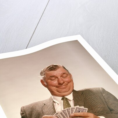 1960s Satisfied Man Looking At Hand Of Playing Cards by Anonymous