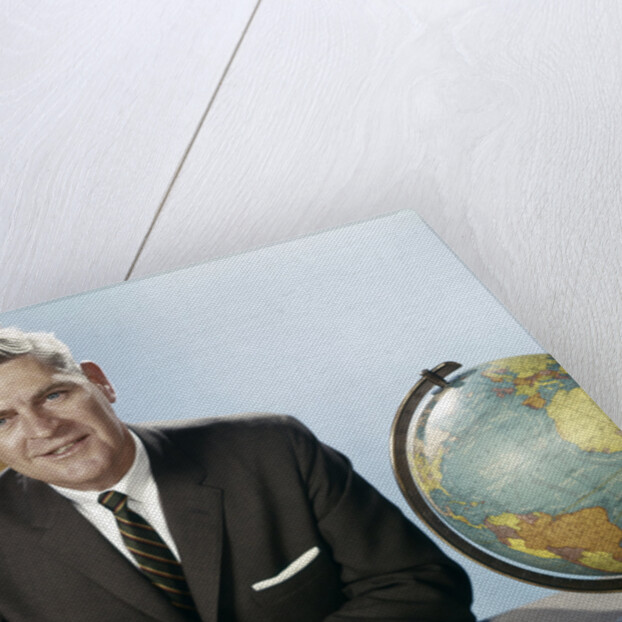 1960s Portrait Man Businessman Sitting At Desk Next To Globe Of The Earth by Anonymous
