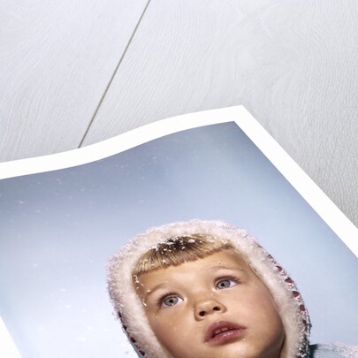 1960s Cold Little Girl In Winter Coat And Hood Looking Up At Falling Snow by Anonymous