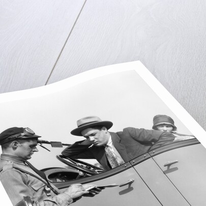 1920s Motorcycle Policeman Writing A Speeding Ticket To A Couple Sitting In Convertible Sedan by Anonymous