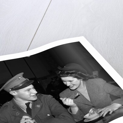 1940s Soldier In Army Uniform And Girlfriend Sitting At Soda Fountain Counter Eating Dish Of Ice Cream by Anonymous