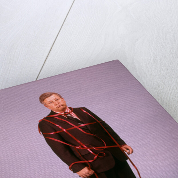 1970s Middle Aged Man Business Suit Disapointed Depressed Unhappy Tied Up In Red Tape by Anonymous