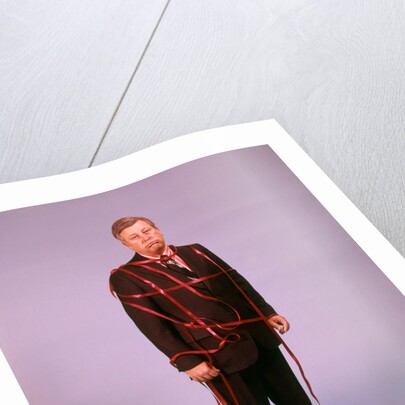 1970s Middle Aged Man Business Suit Disapointed Depressed Unhappy Tied Up In Red Tape by Anonymous