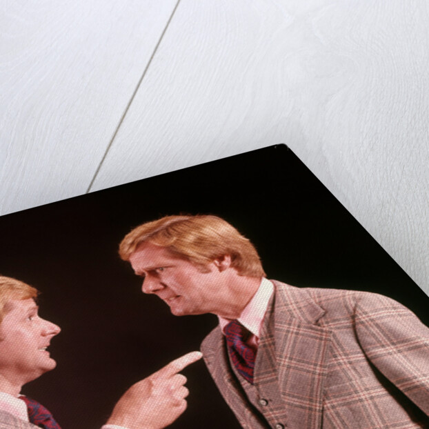 1970s Angry Red Haired Man In Plaid Suit Arguing With Himself by Anonymous
