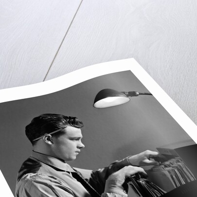 1940s Young Man Office File Clerk Putting Records Into Filing Cabinet Drawer by Anonymous