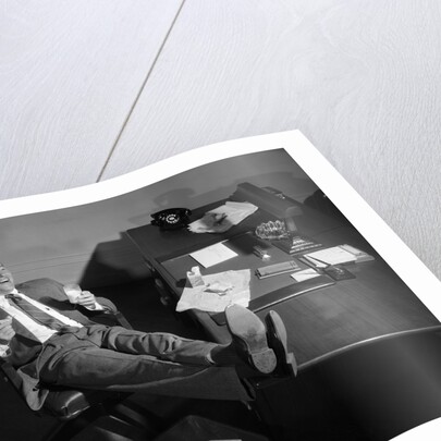 1950s Man Businessman Salesman Eating Lunch In Office With Feet Resting Up On Desk by Anonymous