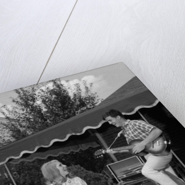 1960s Boy Playing Guitar, Woman Holding Soft Drink Bottle Outside In Backyard by Anonymous