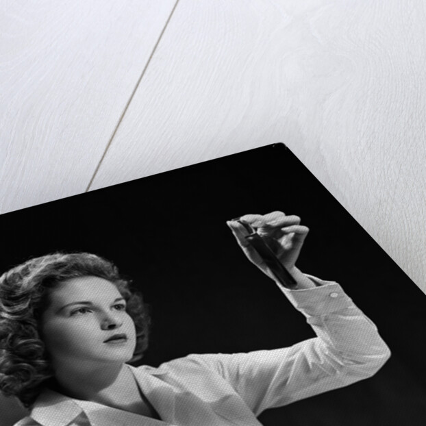 1940s Student Nurse Holding Up Test Tube While Taking Notes In Science Class by Anonymous