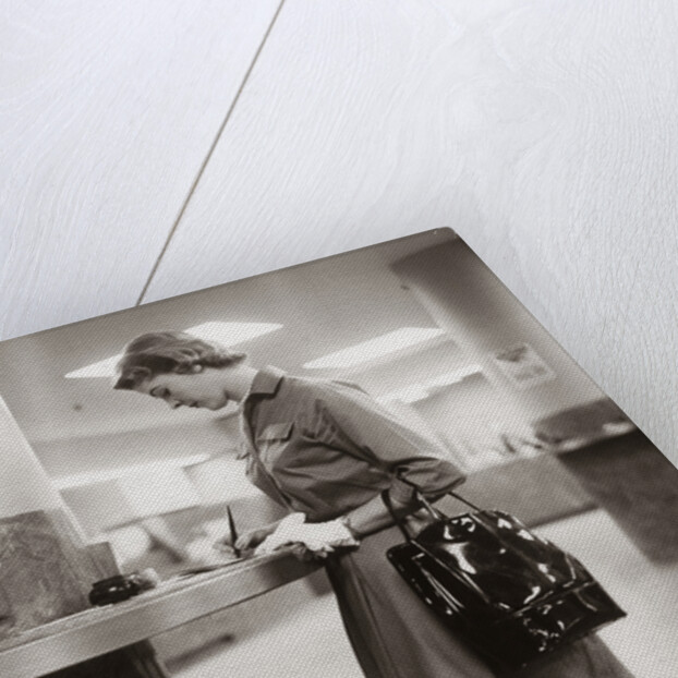 1950s 1960s Woman Handbag On Arm Gloves Filling Out Deposit Slip Bank Counter by Anonymous