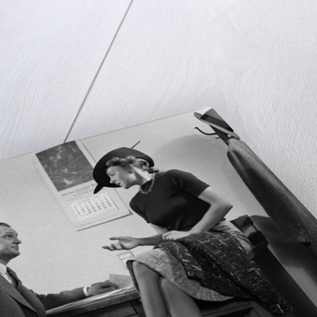 1940s Woman Sitting On Desk Hat Skirt Hand Gesture Talking Flirting With Man by Anonymous
