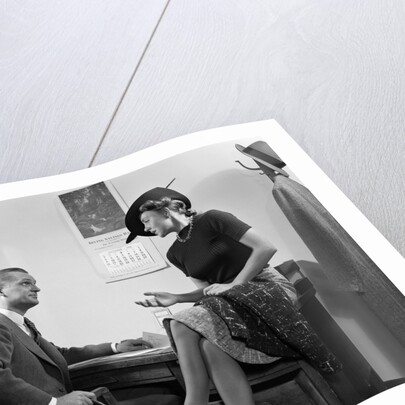 1940s Woman Sitting On Desk Hat Skirt Hand Gesture Talking Flirting With Man by Anonymous